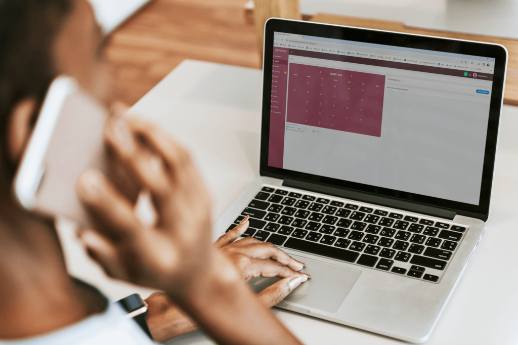 mulher ao telefone com calendario comercial no computador