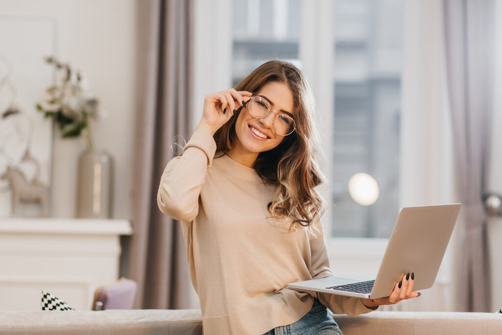 mulher feliz segurando notebook em pé